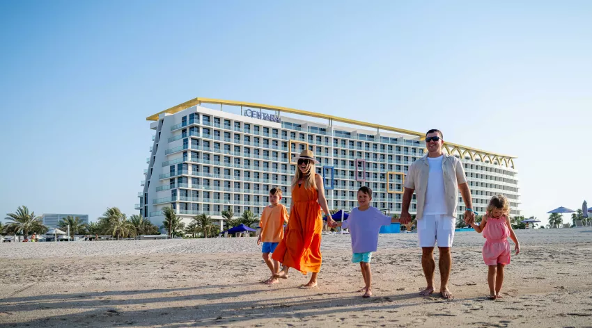 centara mirage beach resort familienhotels in dubai kinderhotel, bild mit familie am strand laufend