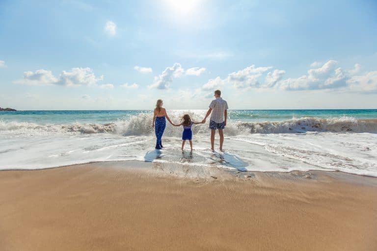 Familienurlaub in Dubai Familie stehend am Strand Richtung Meer