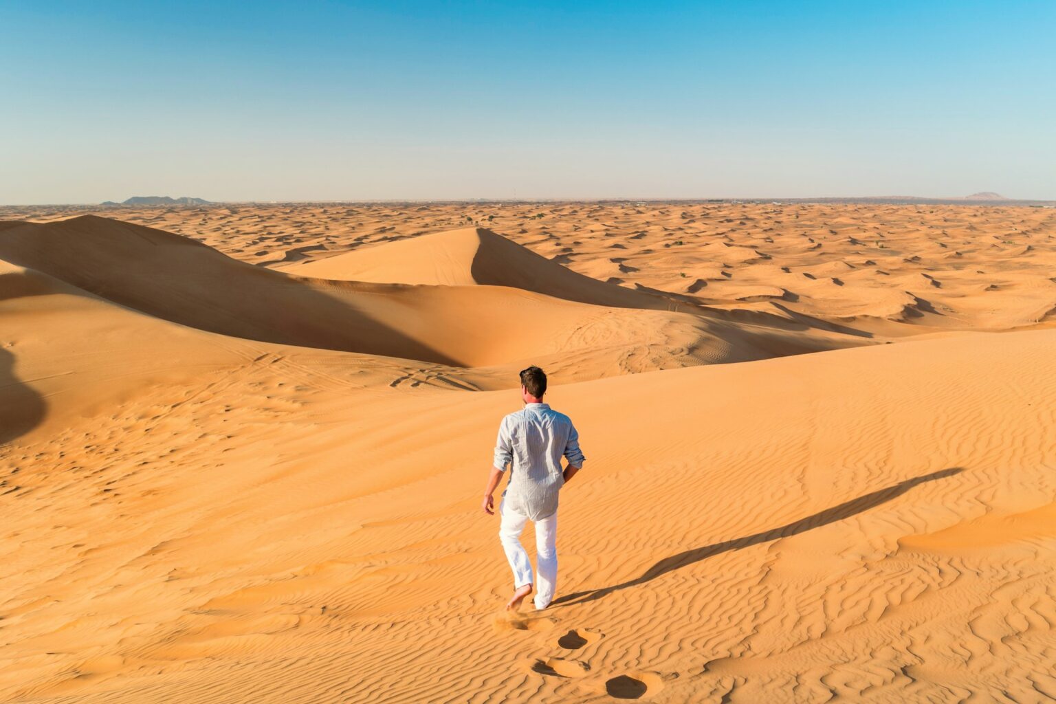 Junger Mann läuft in Dubai bei einer wüstensafari in dubai