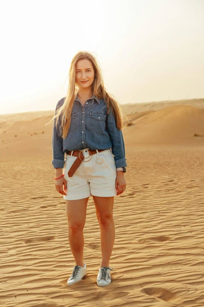 Dubai Attaktion in der Wüste Dubais mit Portrait einer blonden Frau und Sonne im Hintergrund