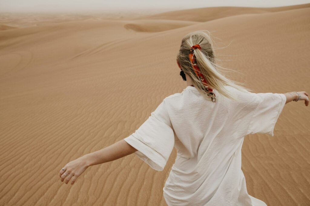Wüste mit rennender Frau breite Arme Dubai Blog Blog über Dubai