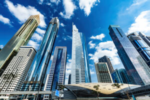 Dubai Urlaub Kosten, Gebäude in Dubai Marina mit strahlendem blauen Himmel mit Wolken