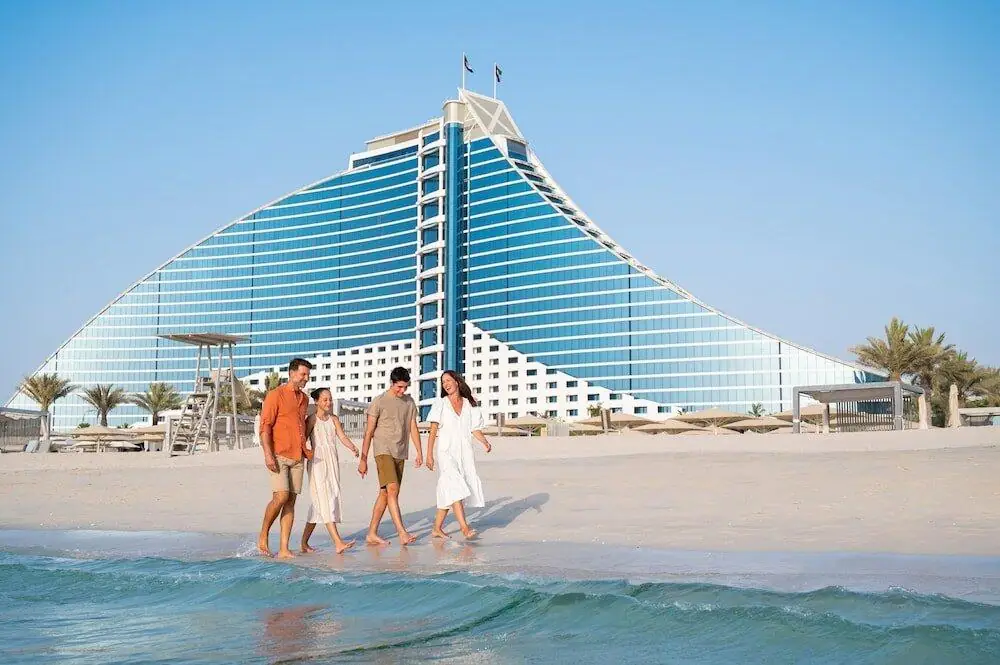 familienhotel in dubai familie läuft am strand des jumeirah beach hotel